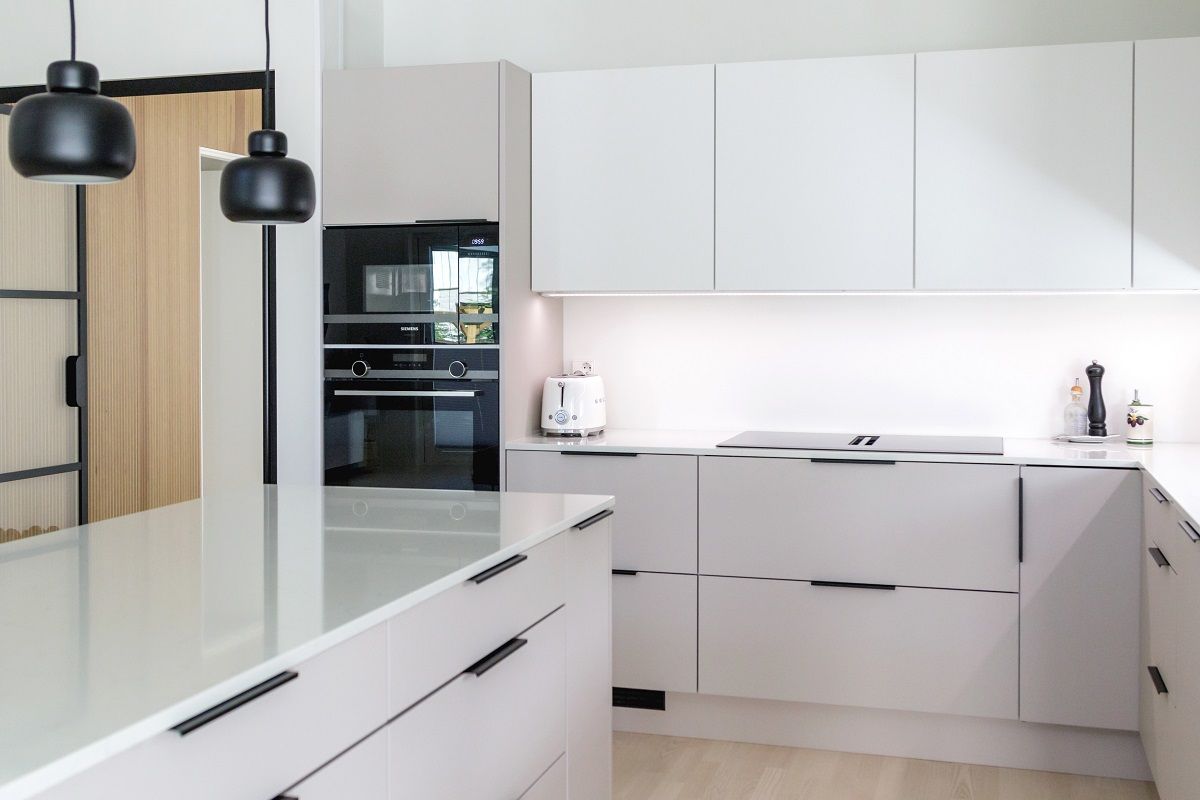 Le superfici chiare della cucina riflettono bene la luce del piano di lavoro.